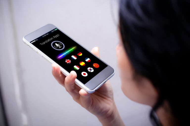 Persona usando una aplicación de traducción por voz en un teléfono móvil durante un viaje.