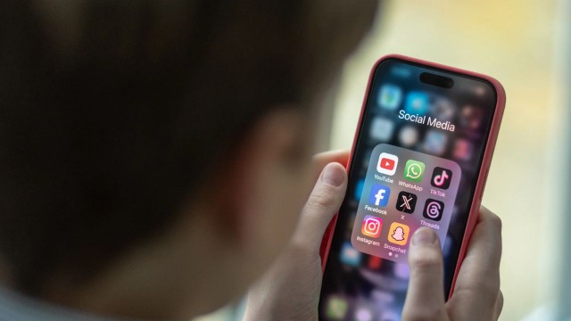 Ilustración de un teléfono móvil con iconos de redes sociales (Facebook, Instagram, TikTok, YouTube) y un candado, representando controles de edad y seguridad en línea.