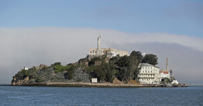 Isla de Alcatraz con el muelle principal en reparación y turistas observando desde un ferry