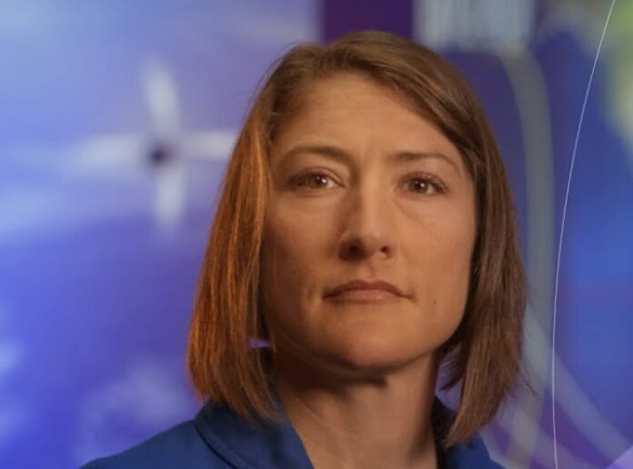 Retrato de la astronauta Christina Koch de la NASA, sonriendo con un fondo azul.
