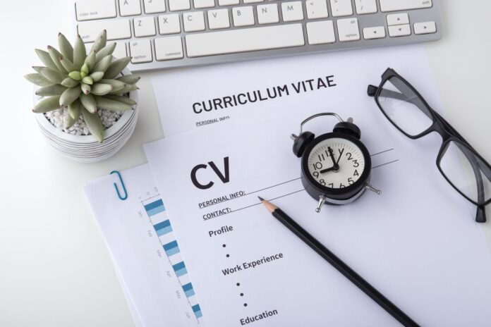 como-optimizar-cv-herramientas-inteligencia-artificial Persona utilizando una laptop para trabajar en la optimización de un currículum vitae con ayuda de herramientas digitales.
