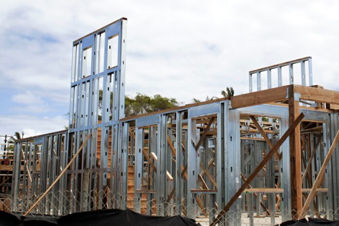 construccion-tradicional-vs-steel-frame-proteccion-inversion-2026 Gráfico comparativo entre una casa de construcción tradicional de ladrillo visto y una estructura de Steel Frame en obra.