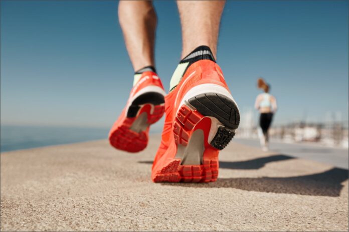 Persona revisando el desgaste de la suela de unas zapatillas para correr.
