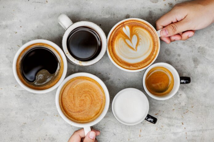 Taza de café junto a un gráfico médico que representa un corazón, simbolizando el estudio sobre salud cardiovascular.