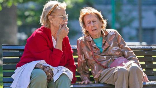 Gráfico estadístico y persona mayor sosteniendo un documento, representando el análisis de datos sobre pobreza en la tercera edad.