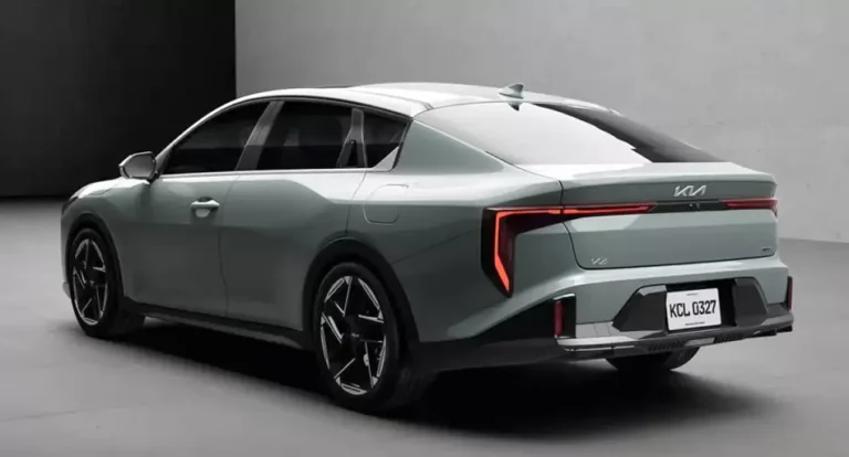 Vista frontal del nuevo sedán Kia K4, color gris, en un entorno urbano.