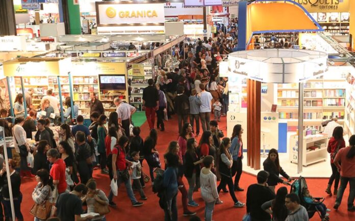 Pila de libros sobre fútbol junto a una pelota, en referencia a las presentaciones en la Feria del Libro.