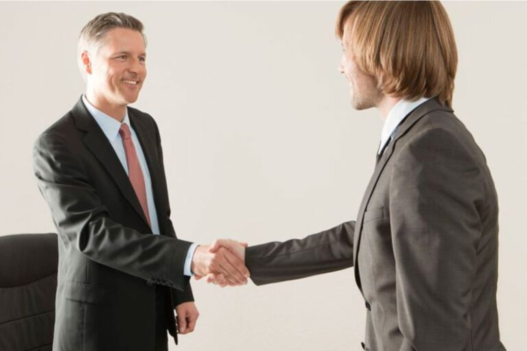 Logo de la Real Academia Española (RAE) junto a un reloj que marca la mañana