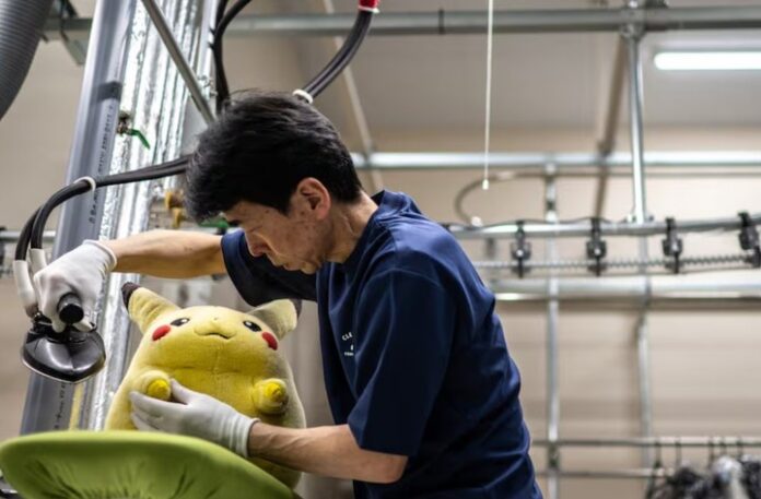 Masakazu Shimura limpiando un peluche de Pikachu con espuma y cepillo en el spa para peluches de Japón
