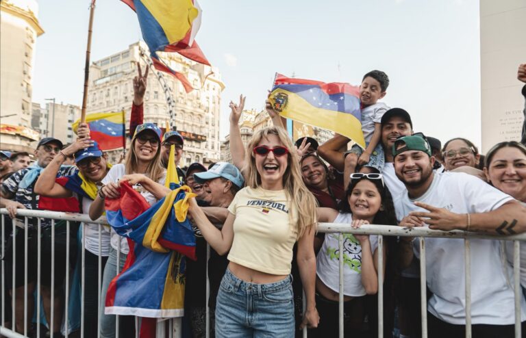 Steffania Uttaro, cantante venezolana, posa con lentes rojos y vestimenta colorida.