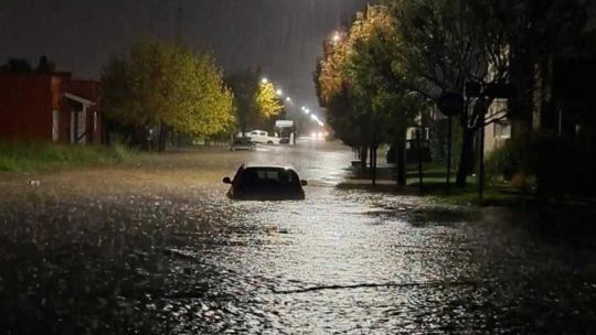 Calle anegada y vehículos afectados por las inundaciones en Coronel Suárez tras el temporal.