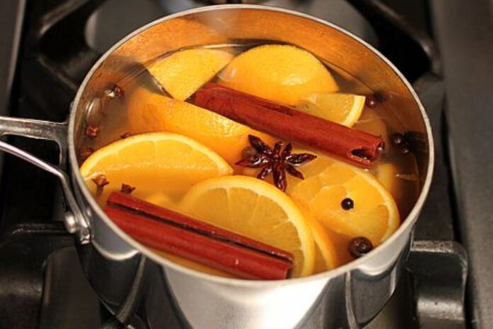Frasco con aceite de oliva, ramas de canela y cáscaras de limón para aromatizar ambientes