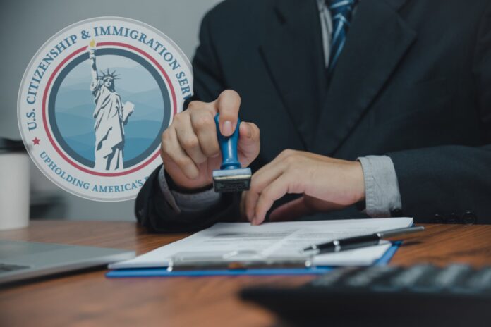 uscis-frena-decisiones-green-cards-permisos-trabajo-daca-tps Oficina del USCIS en Estados Unidos con bandera estadounidense
