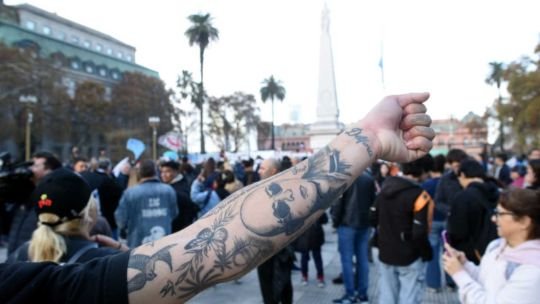 Personas reunidas en el Obelisco con banderas en homenaje al Indio Solari