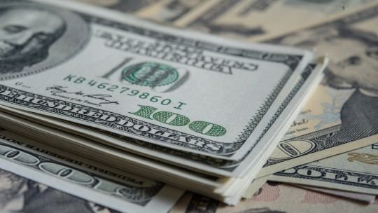 Billetes de dólar y de peso argentino sobre una mesa