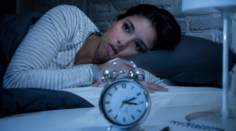 Persona durmiendo en una cama en una habitación oscura
