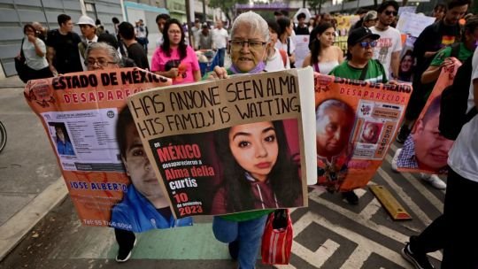 Mujeres con carteles marchando frente a un estadio durante el Mundial 2026