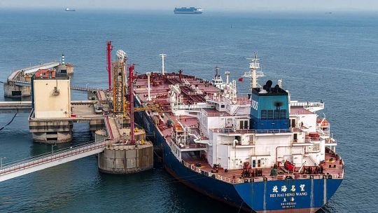 Gráfico de barril de petróleo con precios en descenso y mapa del Estrecho de Ormuz