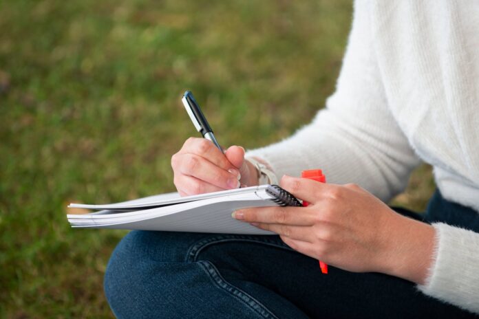 Persona escribiendo en un cuaderno para ordenar sus pensamientos