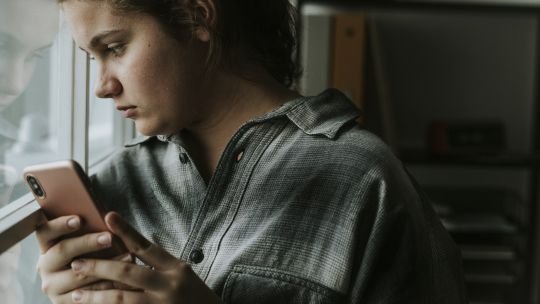 red-contencion-emocional-whatsapp-argentina Persona escribiendo en un teléfono móvil con la interfaz de WhatsApp abierta