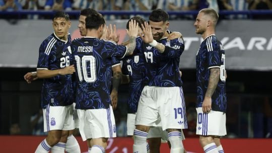 Balón de fútbol sobre el césped con banderas de países clasificados al Mundial 2026
