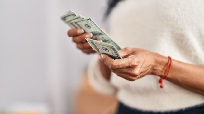 Billetes de dólar sobre una superficie, ilustrando consejos de conservación