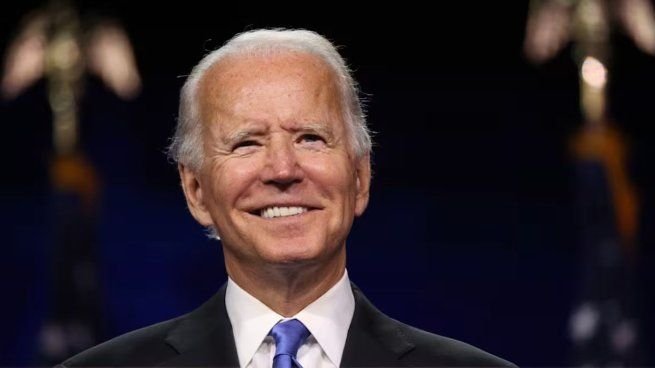 Joe Biden sosteniendo su libro de memorias Promise Me America