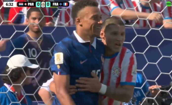 Mbappé y Cáceres en el campo de juego durante el partido Francia vs Paraguay