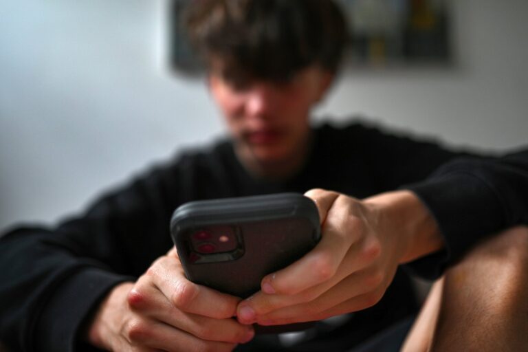 Adolescente usando un teléfono móvil con aplicaciones de redes sociales