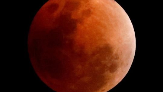 Eclipse lunar parcial visto desde la Tierra, con la Luna teñida de rojo
