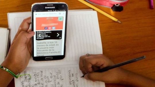 Gráfico de rendimiento educativo en declive con un teléfono inteligente al lado