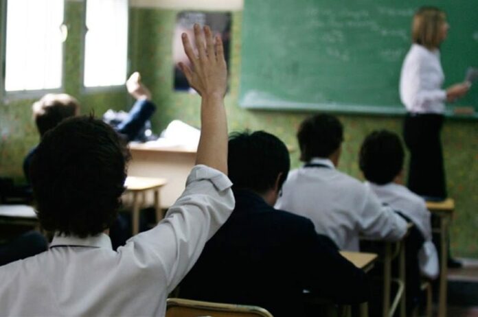Docente en aula con alumnos durante una clase